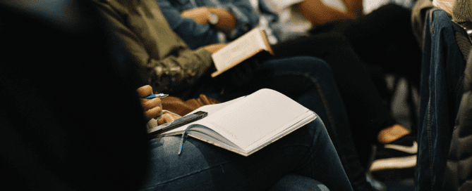 Notebook on the lap of conference attendee