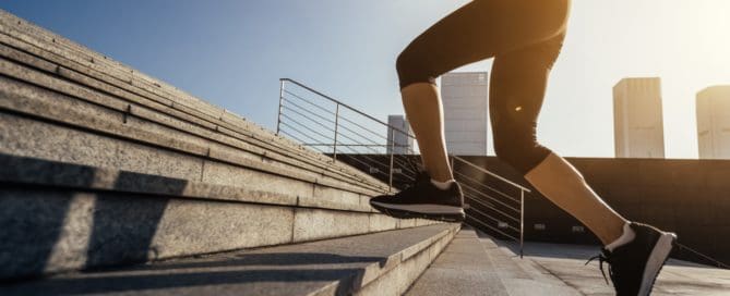 Fitness sports woman running up stairs in city